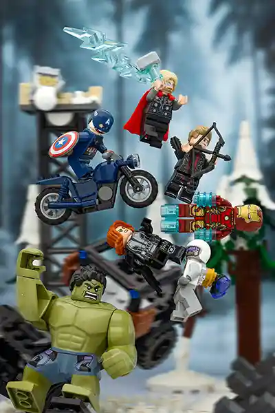 LEGO Avengers minifigures including Captain America, Thor, Hulk, Iron Man, Black Widow, and Hawkeye clash mid-air against Ultron’s forces in a dynamic winter battle scene.