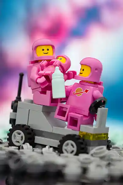A pink space rover with a smiling astronaut minifigure driving it, surrounded by colorful alien plants and a vibrant purple-and-blue cosmic background, capturing the whimsical spirit of LEGO space adventures.