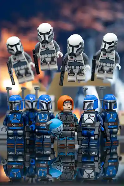 A squad of LEGO Mandalorians, led by Bo-Katan, stands ready while airborne troopers descend in formation against a dramatic battle-scarred sky.