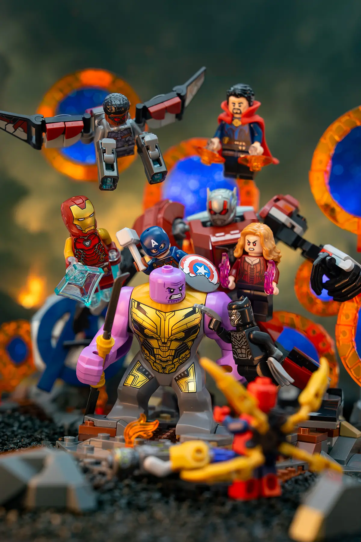 An ensemble of LEGO Avengers assemble around Thanos in a dramatic battlefield scene. The support rods are removed, and vivid orange-blue portals and enhanced lighting give the image a cinematic, Endgame-style impact.