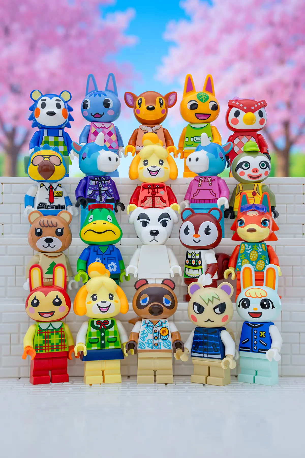 LEGO Animal Crossing minifigures arranged in rows against a vibrant backdrop of cherry blossom trees. Iconic characters like Isabelle, Tom Nook, K.K. Slider, and villagers like Marshal, Rosie, and Raymond are recreated in colorful LEGO form, showcasing their signature outfits and cheerful expressions.